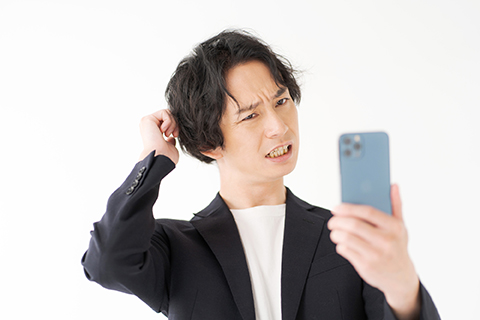携帯電話のトラブルに悩むビジネスマン