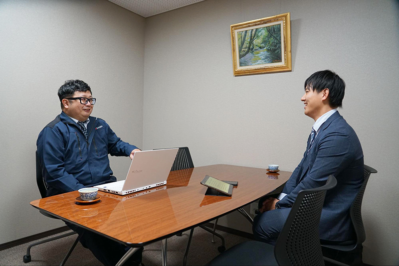 白石担当者と向き合い、法人携帯の管理について話す三信産業の佐藤様